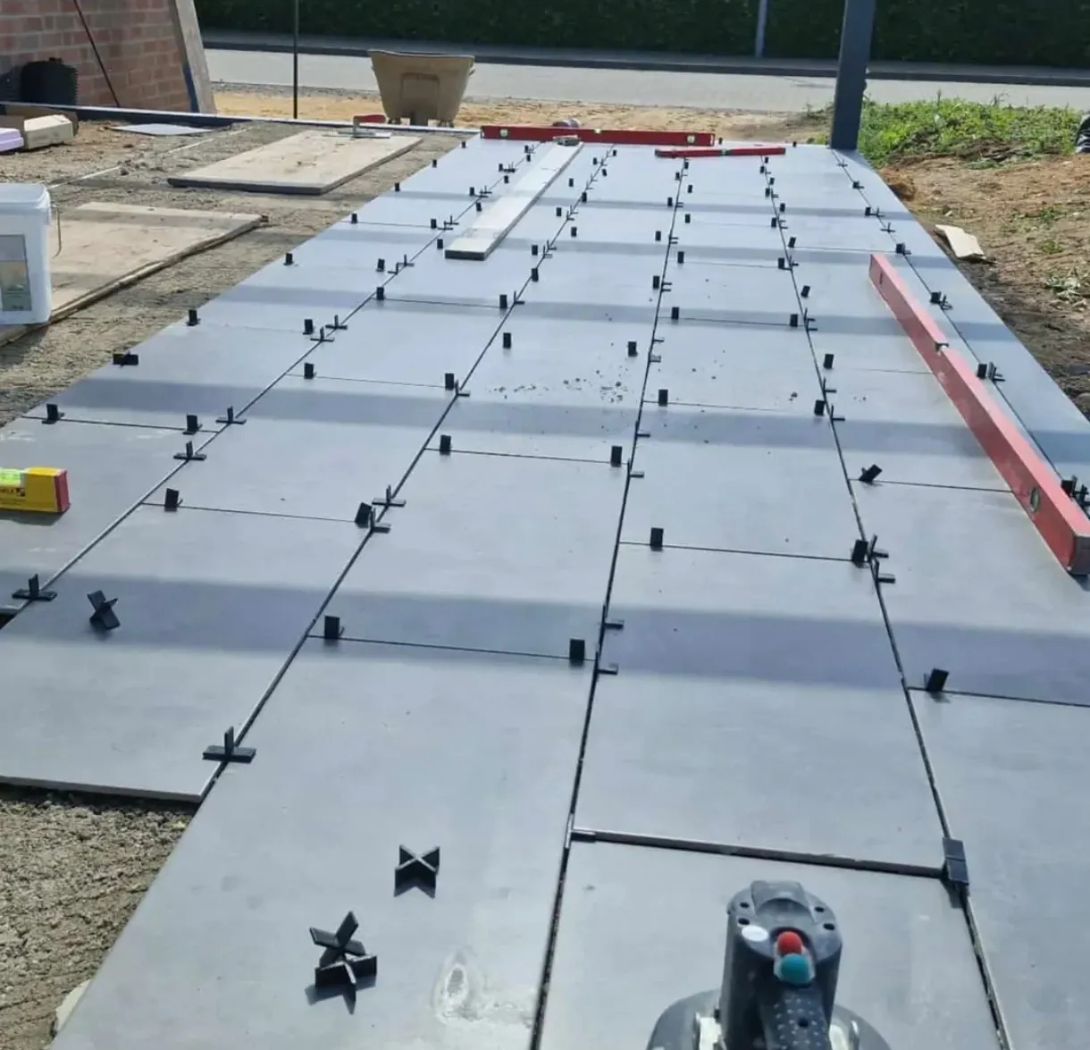 Großformatige Platten werden auf einer Außenfläche verlegt